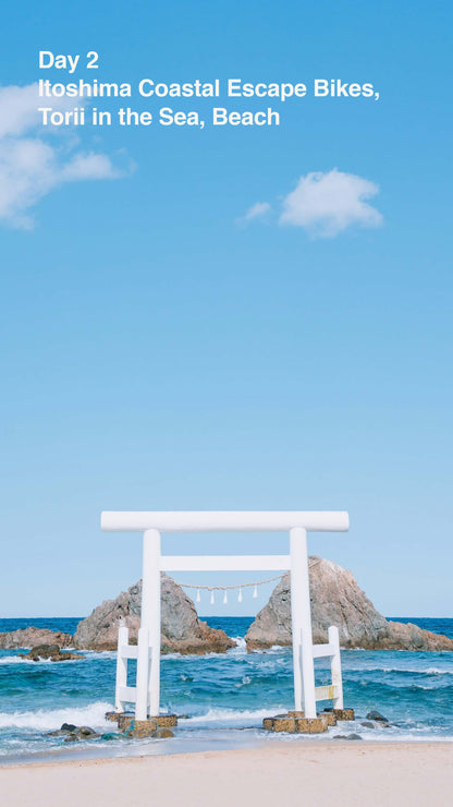White torii gate on a rocky island with blue sky and ocean